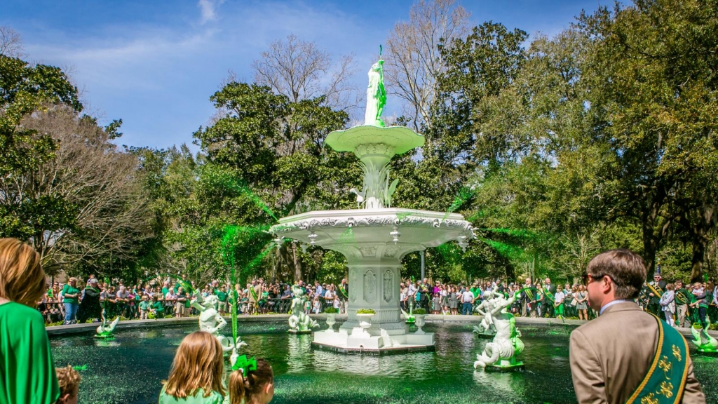 Forsyth Park fountain flowing green with excited festivalgoers in the background